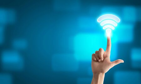 Male hand touching wireless connection icon on modern interfaceの写真素材