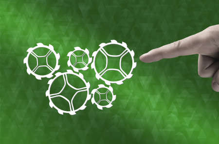 Concept of harmonious working mechanism with finger pointing at gears and cogwheelsの写真素材