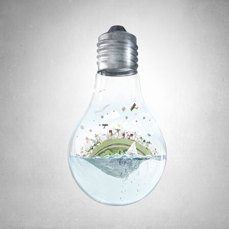 Glass light bulb with water and city island floating insideの写真素材
