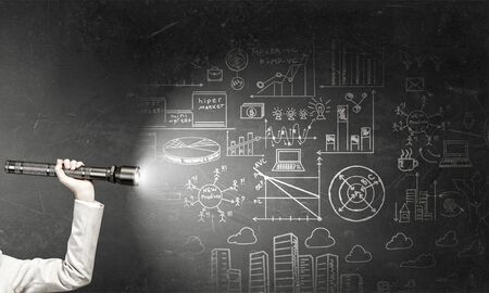 Close up of human hand with lantern and business sketches on wallの写真素材