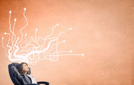 Thoughtful businesswoman and drawn thoughts out of her headの写真素材