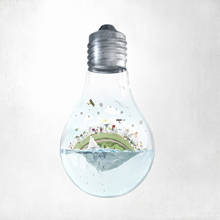 Glass light bulb with water and city island floating inside