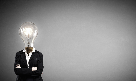 Businesswoman with light electric bulb instead of head as symbol of bright ideaの写真素材