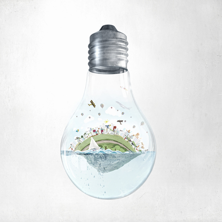 Glass light bulb with water and city island floating insideの写真素材