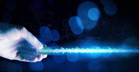 Close up of human hand holding test tube with green sproutの写真素材