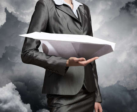 Close view of businesswoman holding paper plane in handの写真素材