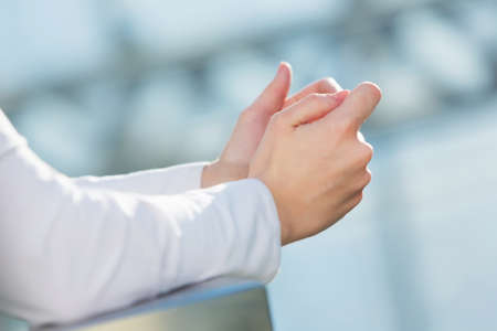 Hands of woman in modern glass interior using her smartphoneの写真素材
