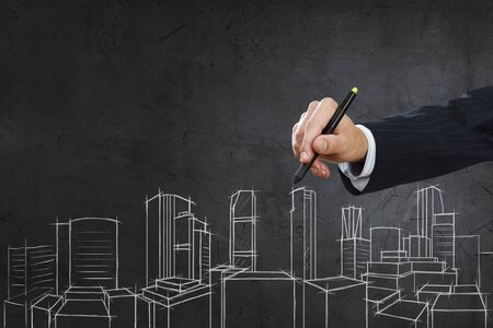 Close up of hand drawing construction project on black wallの写真素材