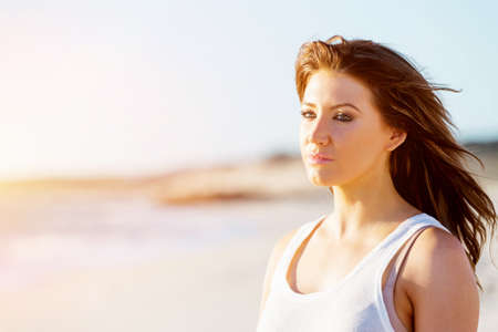 Portrait of young pretty woman relaxing on sandy beach