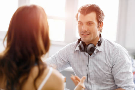 Smiling young designer in office talking to his colleagueの写真素材