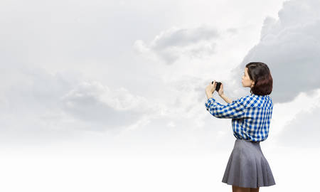 Pretty young girl in casual with retro vintage cameraの写真素材