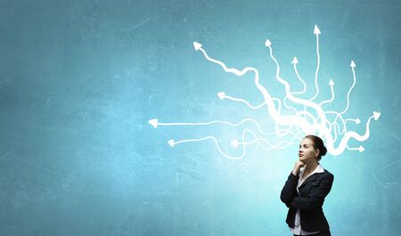 Thoughtful businesswoman and drawn arrow thoughts out of her headの写真素材