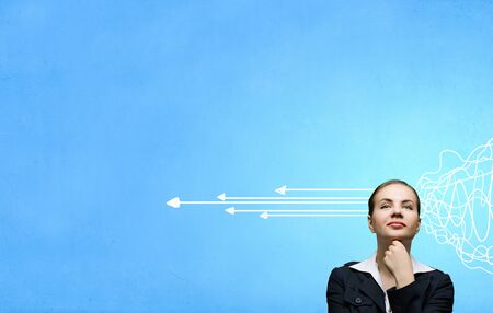 Thoughtful businesswoman and drawn arrow thoughts out of her headの写真素材