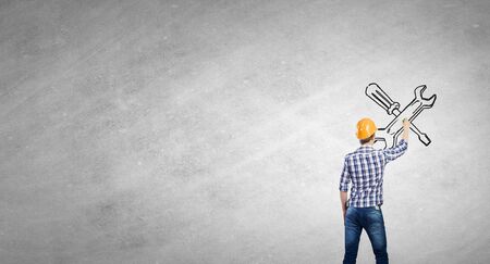 Engineer man standing with back and drawing tools on wallの写真素材