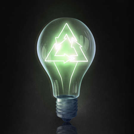 Glass light bulb with recycle sign inside on black background