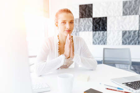 Attractive woman sitting at desk in officeの写真素材