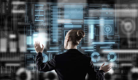 Back view of elegant businesswoman working with virtual panel interface