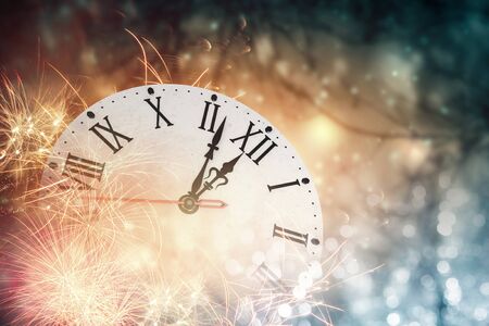 Clock in bokeh lights showing almost midnight