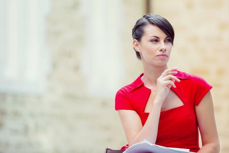 Portrait of business woman in sitting outside and holding papersの写真素材