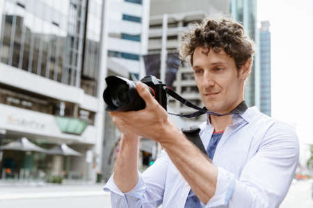 Professional photographer taking picture in cityの写真素材
