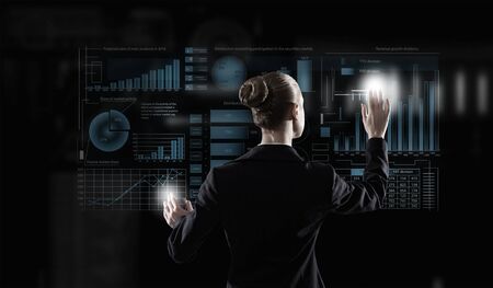 Back view of elegant businesswoman working with virtual panel interface