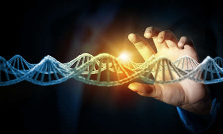 Male hand touching digital image of DNA moleculeの写真素材