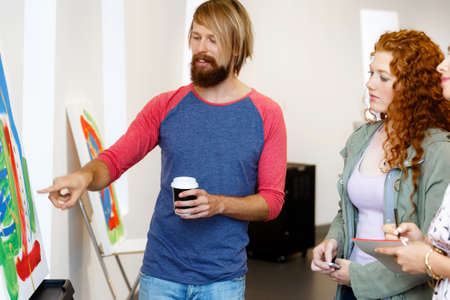 Young people standing in a gallery and contemplating abstract artwork