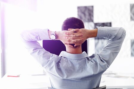 Young businessman sitting at desk in officeの写真素材
