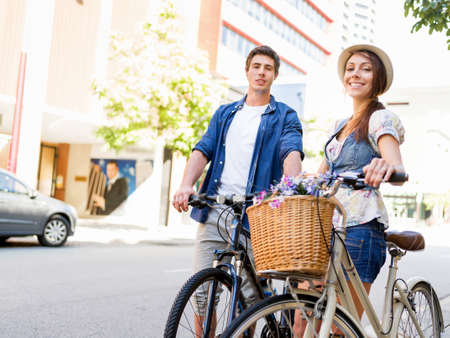 Happy young couple in city with bikeの写真素材