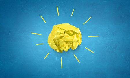 Light bulb with crumpled paper balls on blue backgroundの写真素材