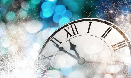 Clock in bokeh lights showing almost midnight