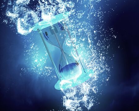 Sandglass item sink in clear blue waterの写真素材