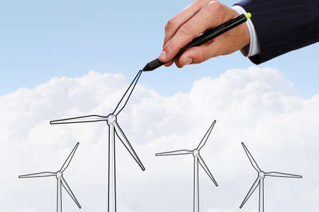 Person hand drawing windmills on sky backgroundの写真素材