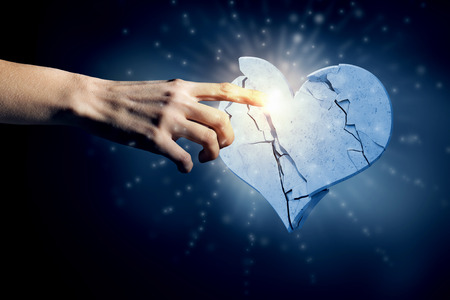 Close up of human hand breaking stone heartの写真素材
