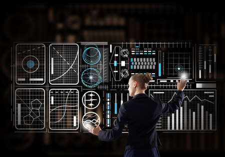 Back view of elegant businesswoman working with virtual panel interface