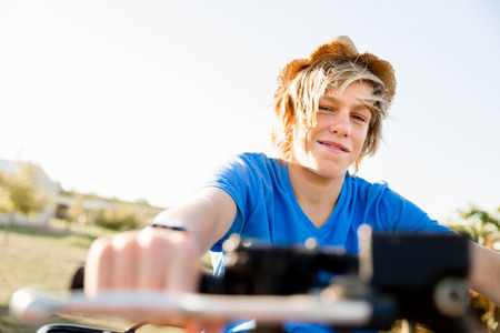 Boy wearing hat and riding farm truck in vineyardの写真素材