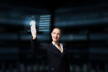 Attractive elegant businesswoman working with virtual panel interfaceの写真素材