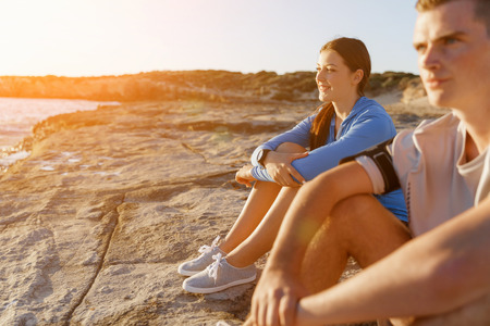 Young coulpe in sport wear sitting on beachの写真素材
