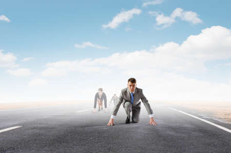 Business people on road in start position ready to runの写真素材