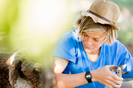 Boy working at farm with a dog