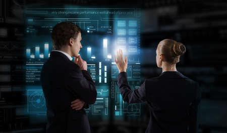 Back view of businesswoman and businessman working with virtual panel interfaceの写真素材
