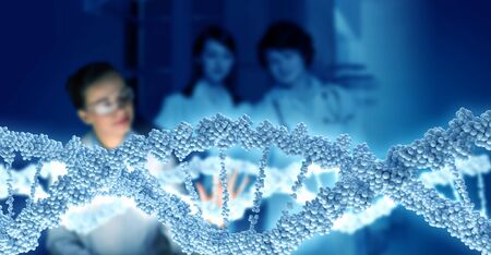 Young scientists looking at DNA molecule image at media screen