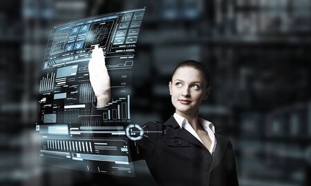 Attractive elegant businesswoman working with virtual panel interface