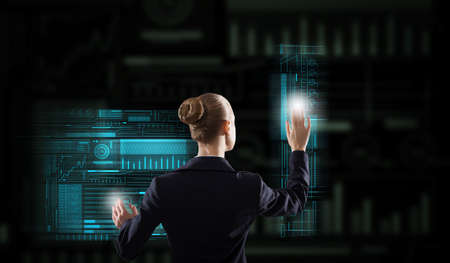 Back view of elegant businesswoman working with virtual panel interface