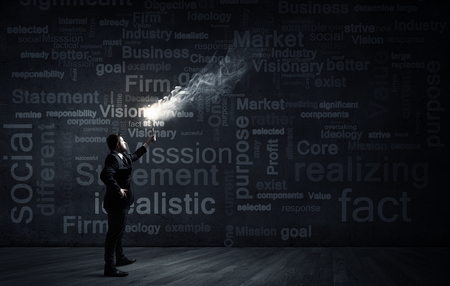 Young businessman in darkness holding burning torch in handの写真素材