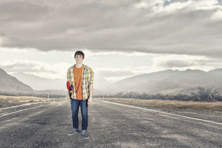 Teenager guy riding skateboard on asphalt roadの写真素材
