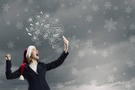 Young businesswoman in Santa hat screaming in mobile phoneの写真素材