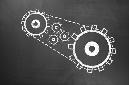 Businessman hand drawing with chalk gears mechanism as teamwork conceptの写真素材