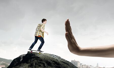 Active teenager guy riding skateboard on rock topの写真素材
