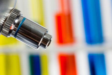 Glass tubes with color liquids and microscope in science laboratory